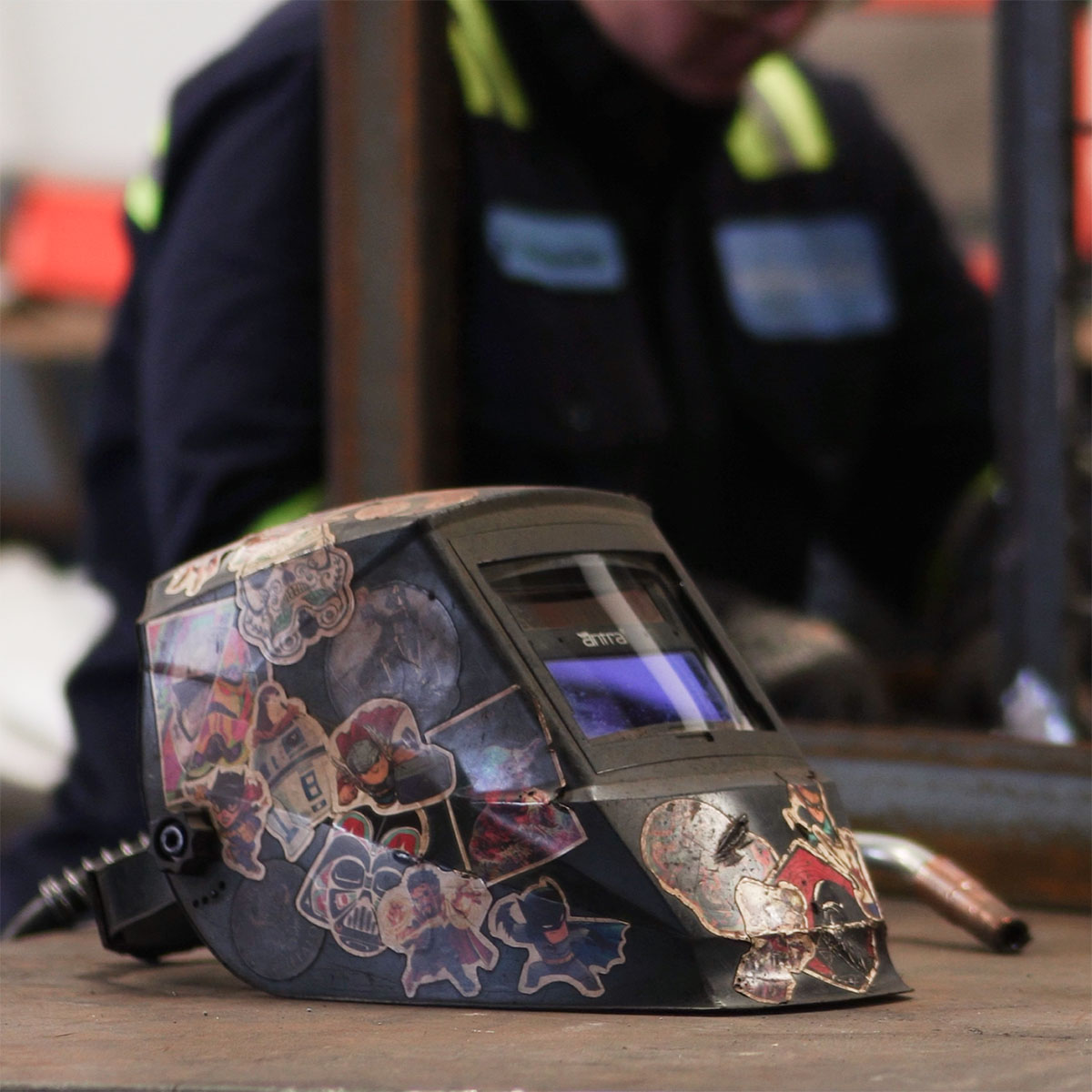 Close-up of a personalized welding helmet at Renfrow+Co showcasing the tools and creativity of the company’s metal fabrication team
