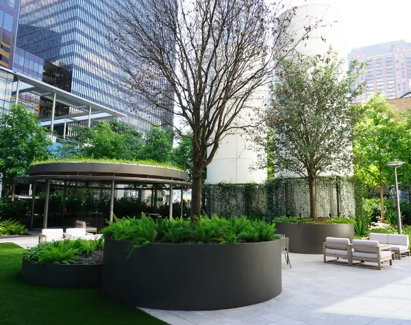 Renfrow+Co's pavilion at 1001 Fannin, featuring circular steel structures and custom planters, set amid lush greenery in downtown Houston Renfrow+Co's pavilion at 1001 Fannin, featuring circular steel structures and custom planters, set amid lush greenery in downtown Houston