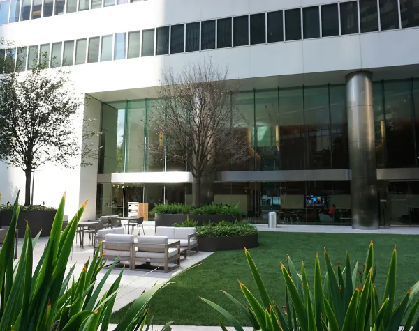 Elegant outdoor space at 1001 Fannin in Houston, showcasing Renfrow+Co's custom planters and seating with a backdrop of a corporate building and lush plants Elegant outdoor space at 1001 Fannin in Houston, showcasing Renfrow+Co's custom planters and seating with a backdrop of a corporate building and lush plants