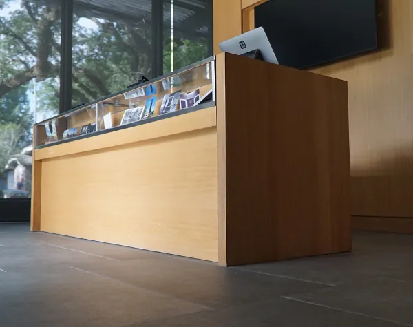 A wooden reception desk with a glass display case at the Rothko Chapel