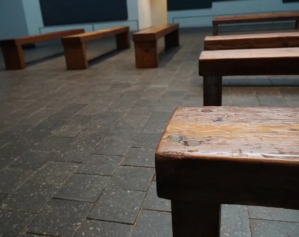 Close-up of refurbished wooden benches inside the Rothko Chapel, showing the intricate texture and patina from Renfrow+Co's restoration work