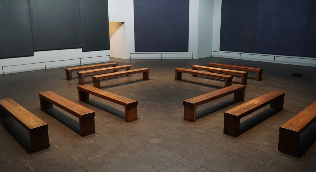 New and refurbished wooden benches arranged in a minimalistic layout inside the Rothko Chapel