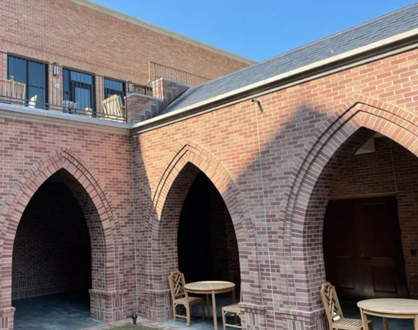 View of St. Martin's Church courtyard, featuring arches, wooden furniture, and brick walls View of St. Martin's Church courtyard, featuring arches, wooden furniture, and brick walls